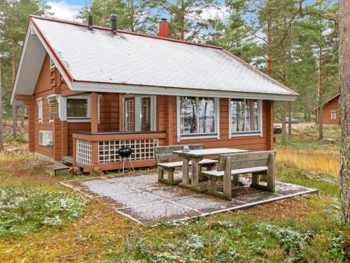 uma pequena casa com uma mesa de piquenique e um banco em Holiday Home Kanerva 4 by Interhome em Isnäs