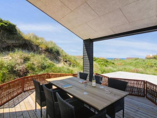 a dining table on a deck with a view of the ocean at Holiday Home Kristiina - 500m from the sea in NW Jutland by Interhome in Saltum