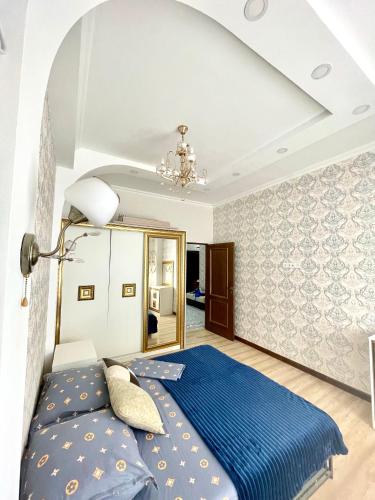 1 dormitorio con cama azul y espejo en Жилой комплекс Green Park, en Aktau