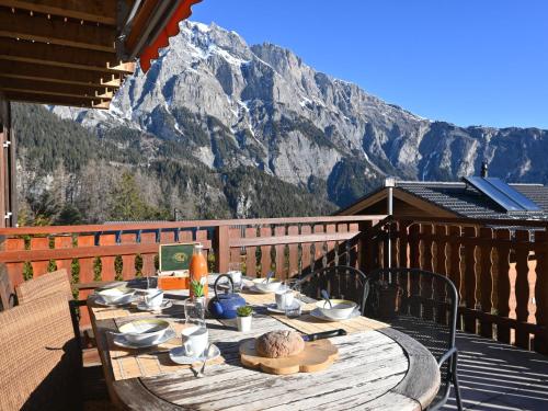 a wooden table on a balcony with a mountain at Chalet Orchidée by Interhome in Ovronnaz