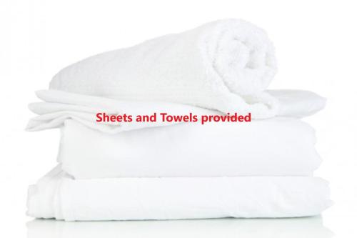 a stack of towels with the words sheets and towels provided at Sunrise Waters 2-63 Soldiers Point Road, stunning waterfront property in Soldiers Point
