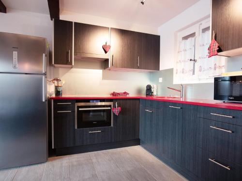 a kitchen with black cabinets and a stainless steel refrigerator at Apartment Chantebrise A2 by Interhome in Chesières