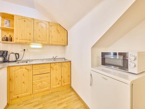 - une cuisine avec des placards en bois et un four micro-ondes dans l'établissement Apartment Villa Belvedere-6 by Interhome, à Janské Lázně
