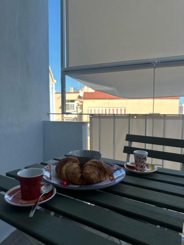 a table with two plates of croissants and cups on it at Tra mare e castello in Barletta