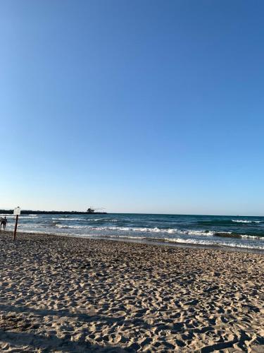 a beach with a sign in the sand and the ocean at Tra mare e castello in Barletta