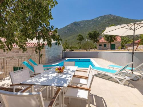 a patio with a table and chairs and a swimming pool at Holiday Home Villa Roglić by Interhome in Roglići
