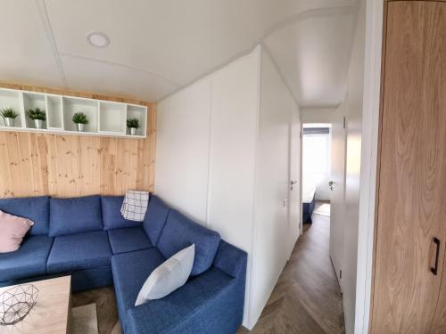 a living room with a blue couch and white walls at Holiday Home Tiny Haus Flussblick by Interhome in Riedenburg