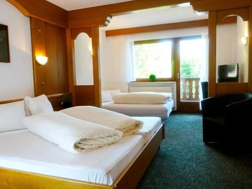 a hotel room with two beds and a window at Apartment Dreizimmer- by Interhome in Feichten