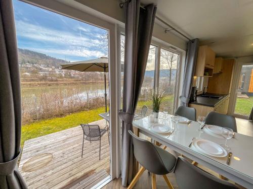 a dining room with a table and a large window at Holiday Home Tiny Haus Flussblick by Interhome in Riedenburg