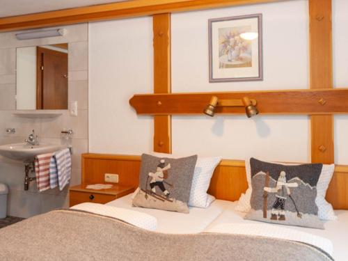 a bedroom with a bed with two pillows and a sink at Apartment Aurora Apartment Top I by Interhome in Kappl