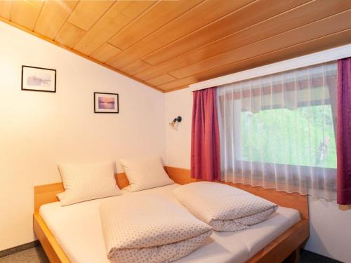 a small bedroom with a bed and a window at Apartment Aurora Apartment Top I by Interhome in Kappl