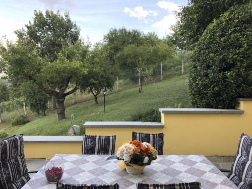 einen Tisch mit einer Blumenvase auf einer Terrasse in der Unterkunft Holiday Home Bellavista by Interhome in Acqui Terme