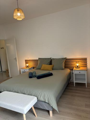 a large bed in a room with two tables at Charme des quais, proche centre et plage in Dunkerque