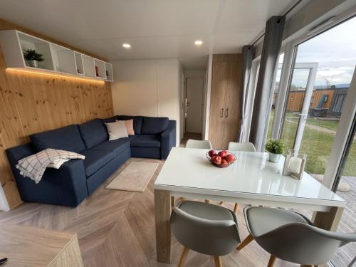 ein Wohnzimmer mit einem blauen Sofa und einem Tisch in der Unterkunft Holiday Home Tiny Haus Burgblick by Interhome in Riedenburg