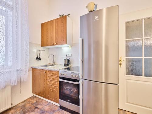 a kitchen with a stainless steel refrigerator and wooden cabinets at Apartment Villa Belvedere-4 by Interhome in Janske Lazne