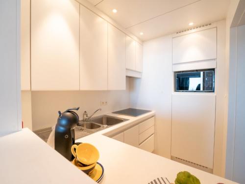 cocina con armarios blancos y encimera en Apartment Seaview Getaway Belgium by Interhome, en Blankenberge