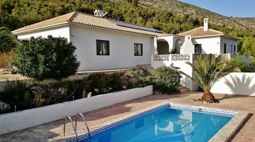 a villa with a swimming pool in front of a house at Chalet Paraiso in Sella
