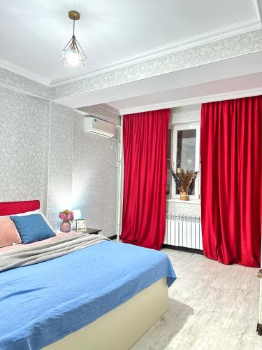 a bedroom with red curtains and a bed at ЖК Тыныштык in Aktau