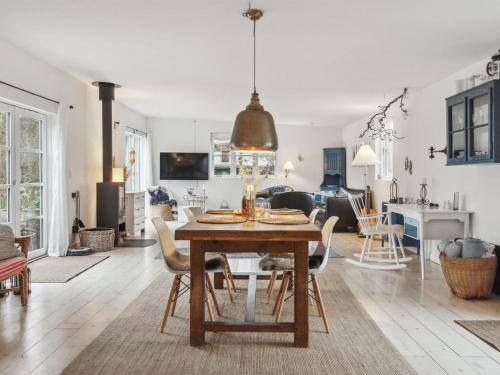 - une salle à manger et un salon avec une table et des chaises dans l'établissement Holiday Home Kielo - 650m from the sea in Sealand by Interhome, à Nykøbing Sjælland