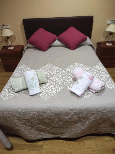 a bed with pillows and towels on it at Casa Rural La Maestra in Sigüés