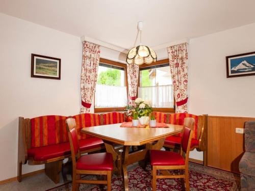une salle à manger avec une table et des chaises rouges dans l'établissement Apartment Top II by Interhome, à Kappl