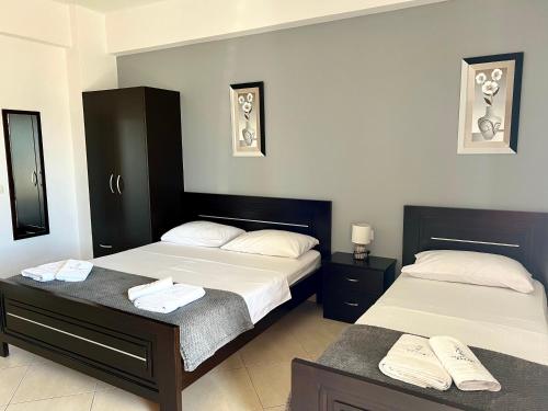 two beds in a hotel room with towels on them at Apartments Klajdi in Sarandë