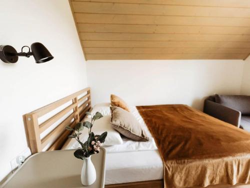 a bedroom with a bed and a vase of flowers on a table at Holiday Home Domek pod Szarowym Lasem by Interhome in Wisła