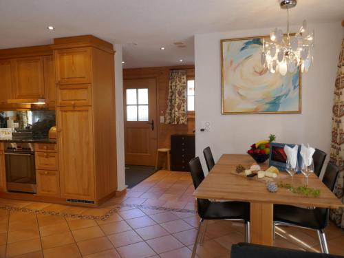 een keuken en eetkamer met een tafel en stoelen bij Apartment Chalet Pfingstrose by Interhome in Grindelwald