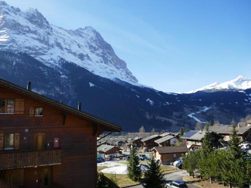 een dorp met een met sneeuw bedekte berg op de achtergrond bij Apartment Chalet Pfingstrose by Interhome in Grindelwald