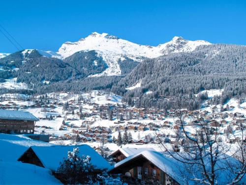 a town covered in snow with mountains in the background at Apartment Chalet Pfingstrose by Interhome in Grindelwald
