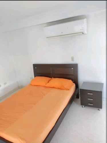 een kleine slaapkamer met een bed en een nachtkastje bij Apartaestudio en arriendo in Neiva