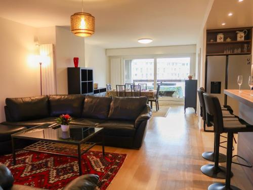 uma sala de estar com um sofá de couro e uma mesa em Apartment Petit Saconnex 28A by Interhome em Genebra