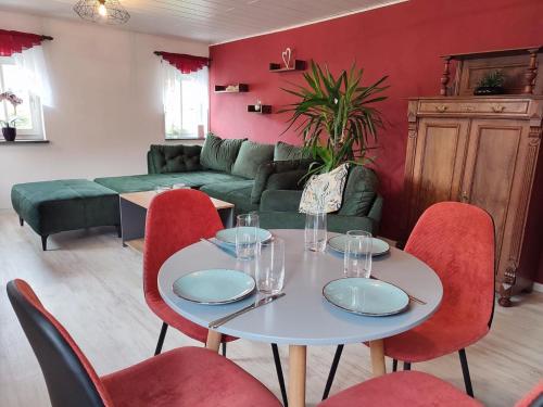 a living room with a white table and red chairs at Holiday Home Selma by Interhome in Großschönau