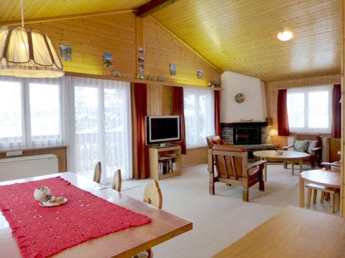 Chalet Chalet Larix by Interhome في برخن: غرفة معيشة مع طاولة طعام وتلفزيون