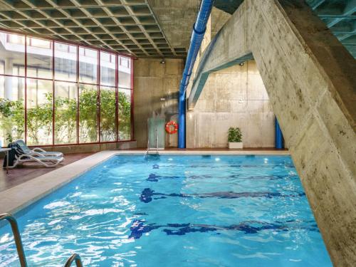 uma grande piscina interior com água azul em Apartment Parque Botanico by Interhome em Estepona