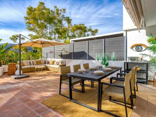 een patio met een tafel en stoelen en een bank bij Apartment Parque Botanico by Interhome in Estepona