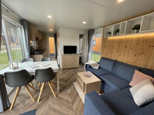 a living room with a blue couch and a table at Holiday Home Tiny Haus Xandra by Interhome in Riedenburg