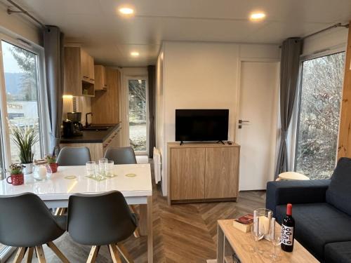 a living room with a couch and a table with chairs at Holiday Home Tiny Haus Antonia by Interhome in Riedenburg