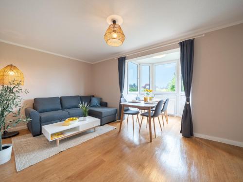 ein Wohnzimmer mit einem blauen Sofa und einem Tisch in der Unterkunft Apartment Hansekogge-1 by Interhome in Cappel-Neufeld