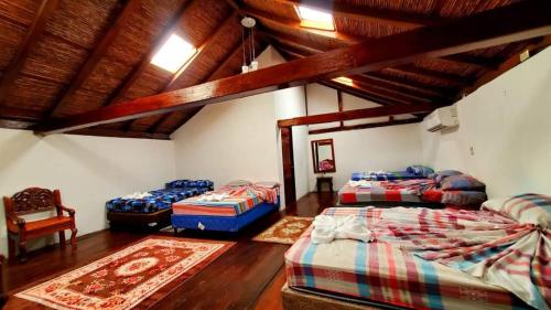 a room with three beds in a room with wooden ceilings at Hotel Camaleon Granada in Granada