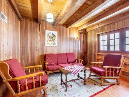 uma sala de estar com cadeiras vermelhas, um sofá e uma mesa em Holiday Home Le Tre Cime by Interhome 