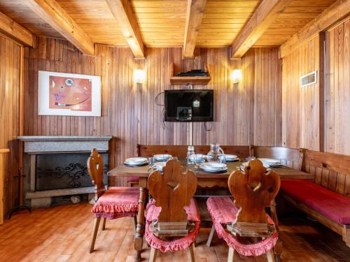 a dining room with a table and chairs and a tv at Holiday Home Le Tre Cime by Interhome 