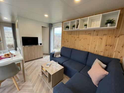 a living room with a blue couch and a table at Holiday Home Tiny Haus Schleusenblick by Interhome in Riedenburg