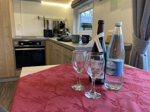 a bottle of wine and two glasses on a table at Holiday Home Neschtle by Interhome in Wemding