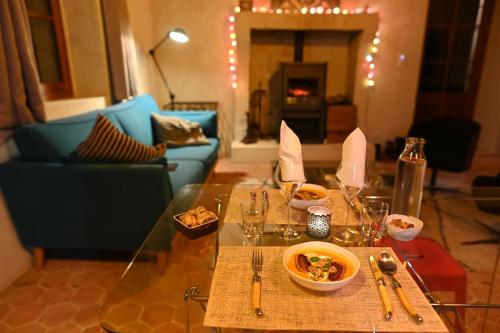 una sala de estar con una mesa de cristal con comida. en une oasis dans le perche en Rémalard