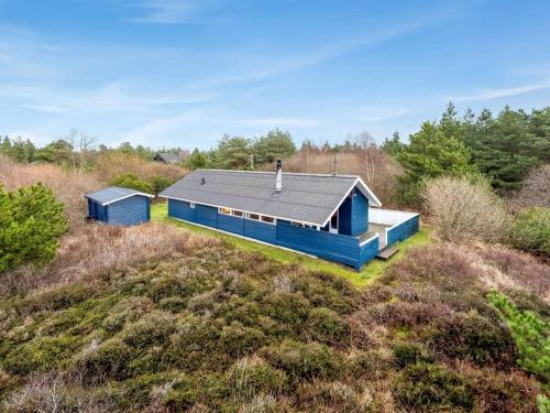 una casa azul en la cima de un campo en Holiday Home Elpida - 2km from the sea in Western Jutland by Interhome, en Lakolk