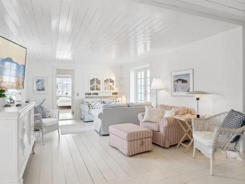 sala de estar blanca con sofá y sillas en Holiday Home Jeppe - 200m from the sea in NW Jutland by Interhome, en Blokhus