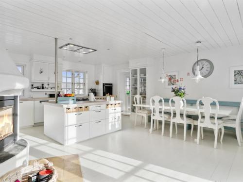 ブロックフスにあるHoliday Home Jeppe - 200m from the sea in NW Jutland by Interhomeの白いキャビネット、テーブルと椅子付きのキッチンが備わります。