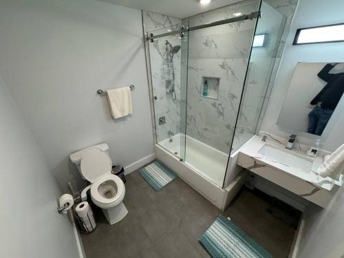 a bathroom with a shower and a toilet and a sink at The Elegant Suite - 2BR with Great Amenities in Paterson