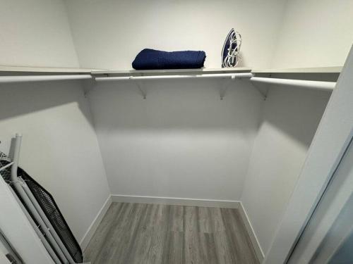 a white room with a shelf with a blue towel at The Elegant Suite - 2BR with Great Amenities in Paterson